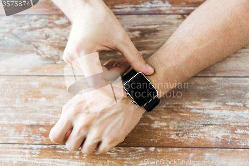 Image of close up of male hands setting smart watch