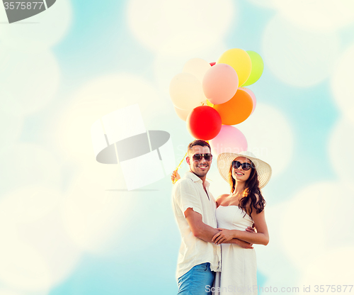 Image of smiling couple with air balloons outdoors