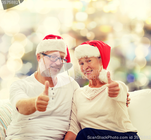 Image of happy senior couple in santa helper hats