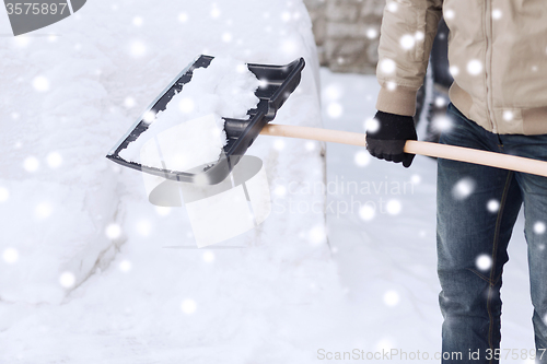 Image of closeup of man digging snow with shovel near car