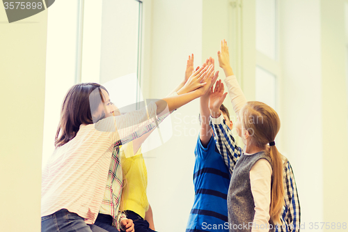 Image of group of school kids making high five gesture