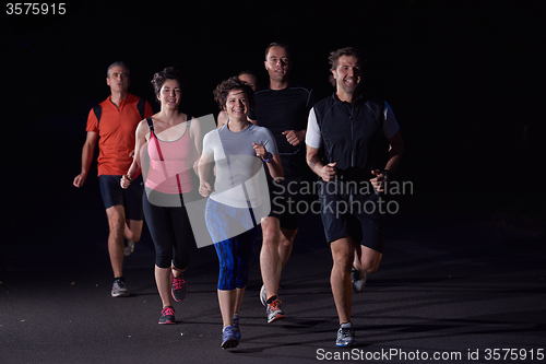 Image of people group jogging at night