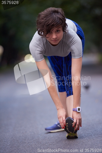 Image of woman  stretching before morning jogging
