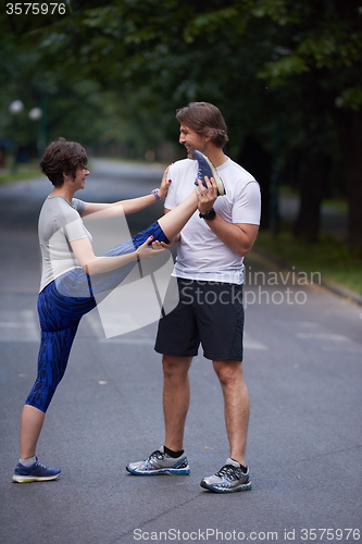 Image of jogging couple stretching