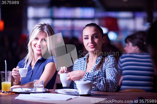 Image of girls have cup of coffee in restaurant