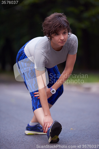 Image of woman  stretching before morning jogging
