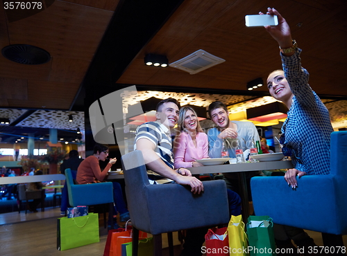 Image of friends have lanch break in shopping mall