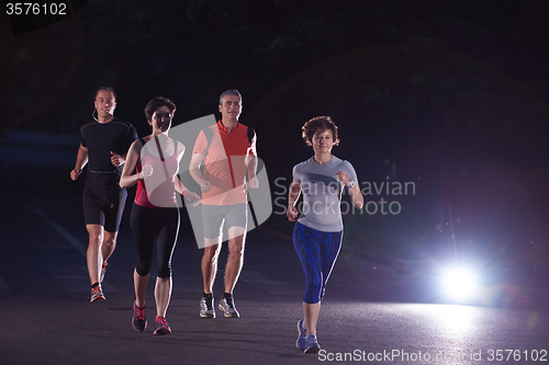 Image of people group jogging at night