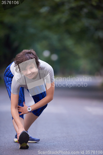 Image of woman  stretching before morning jogging