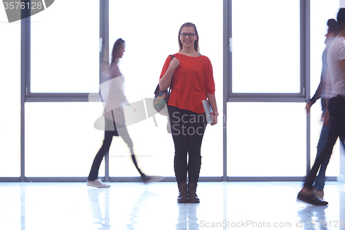 Image of student girl standing with laptop, people group passing by