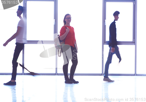 Image of student girl standing with laptop, people group passing by