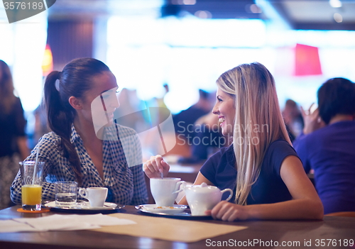 Image of girls have cup of coffee in restaurant