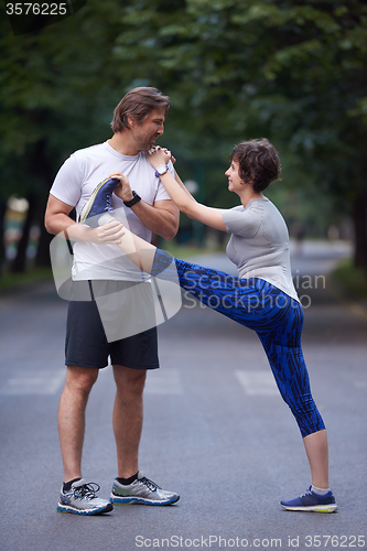 Image of jogging couple stretching