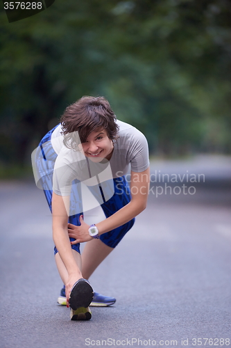 Image of woman  stretching before morning jogging