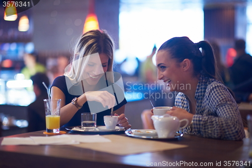 Image of girls have cup of coffee in restaurant