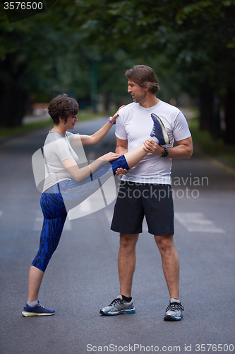 Image of jogging couple stretching