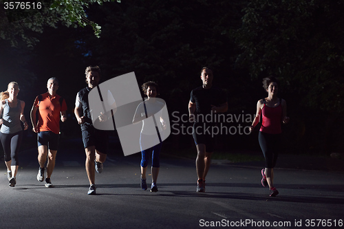 Image of people group jogging at night