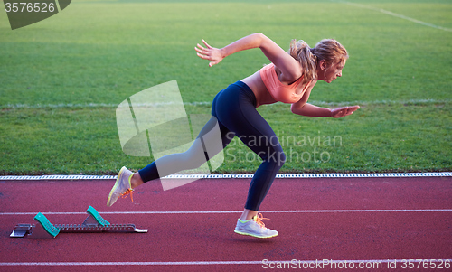 Image of pixelated design of woman  sprinter leaving starting blocks