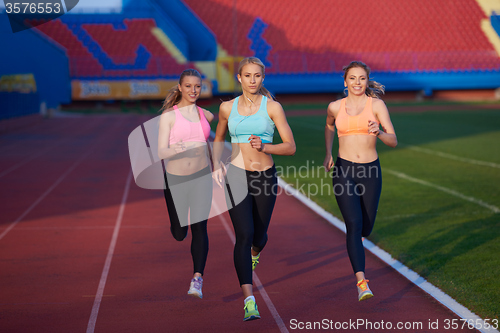 Image of athlete woman group  running on athletics race track