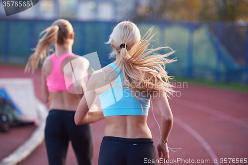 Image of athlete woman group  running on athletics race track