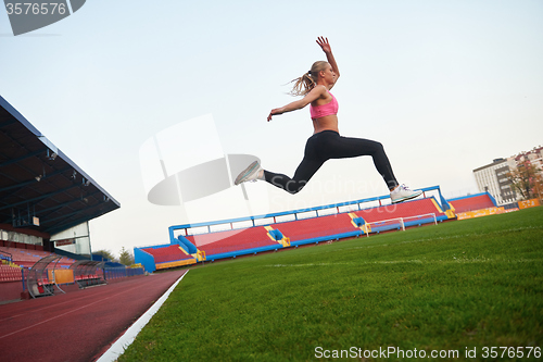 Image of Athletic woman running on track