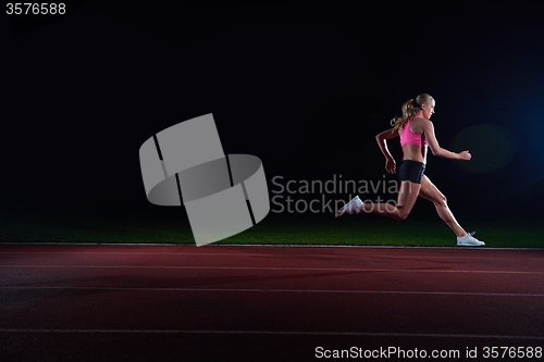 Image of Athletic woman running on track