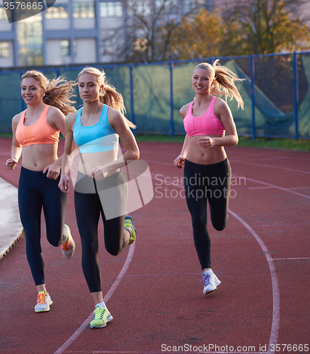 Image of athlete woman group  running on athletics race track