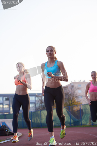 Image of athlete woman group  running on athletics race track