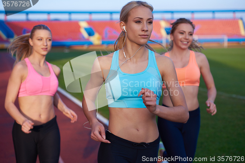 Image of athlete woman group  running on athletics race track