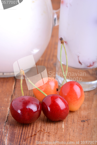 Image of a delicious cherry milkshake on wooden plate