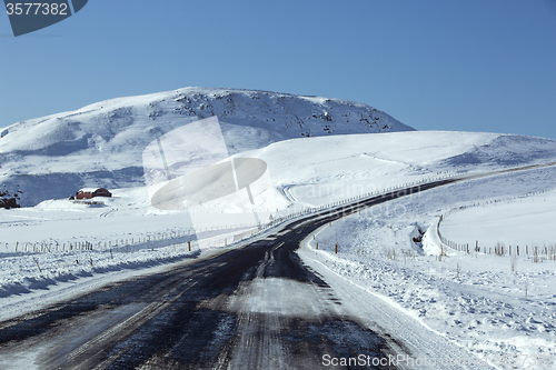 Image of Snowy and slippery road with volcanic mountains in wintertime