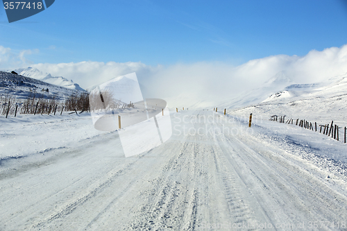 Image of Snowy and icy road with volcanic mountains in wintertime