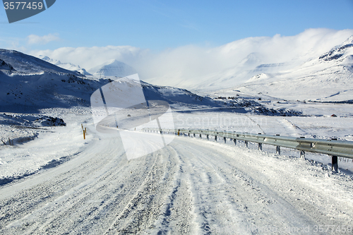 Image of Snowy and icy road with volcanic mountains in wintertime