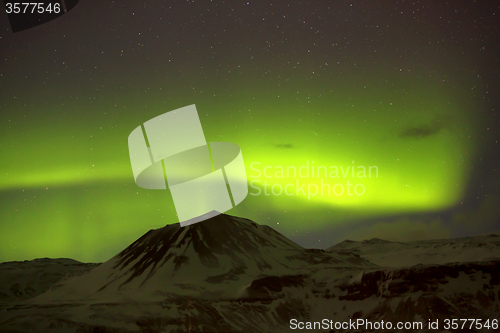 Image of Northern lights with snowy mountains in the foreground