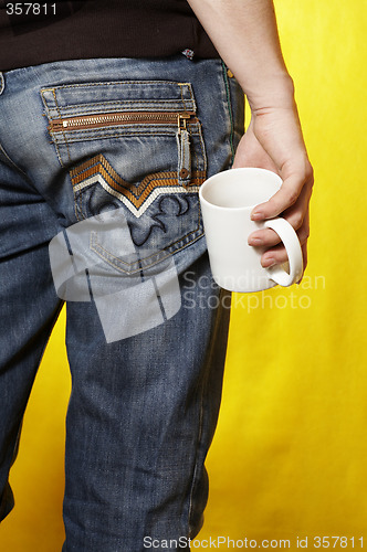 Image of a young caucasian man with white tea cup