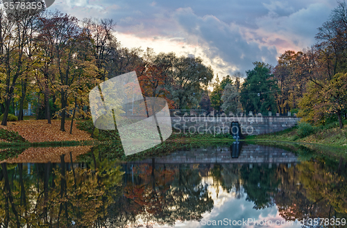 Image of Autumn lake with stone bridge at evening