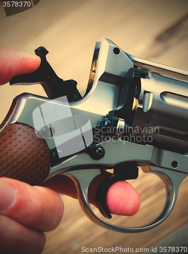 Image of revolver with the hammer cocked in his hand