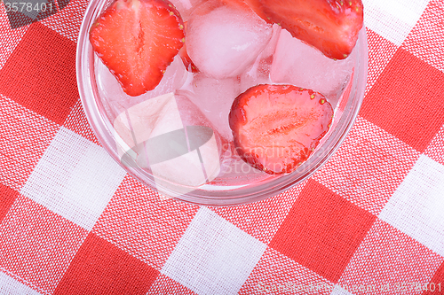 Image of A slice of red strawberry on glass plate in party theme background