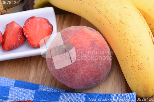 Image of peach strawberry bananas mandarin close up as health food concept