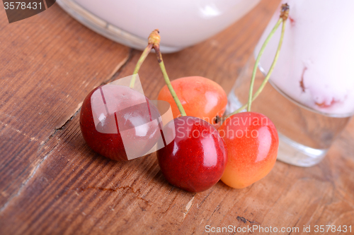 Image of a delicious cherry milkshake on wooden plate