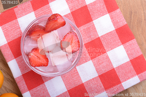 Image of A slice of red strawberry on glass plate in party theme background