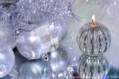 Image of Christmas decorations with candle and silver balls.