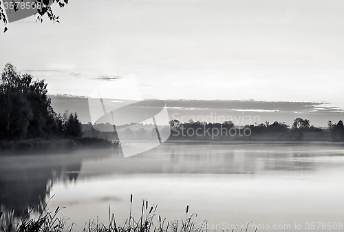 Image of The morning landscape with sunrise over water in the fog. Black 