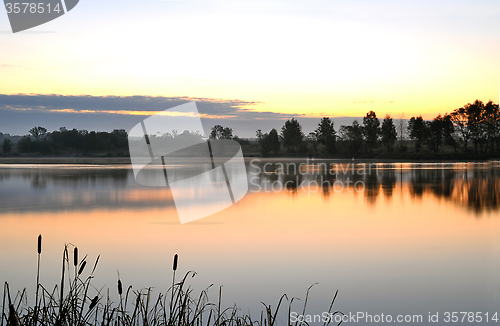 Image of The morning landscape with sunrise over water in the fog