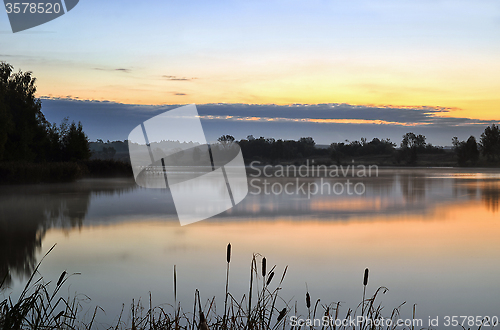 Image of The morning landscape with sunrise over water in the fog