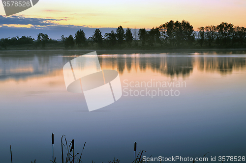 Image of The morning landscape with sunrise over water in the fog