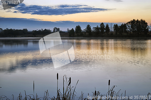 Image of The morning landscape with sunrise over water in the fog