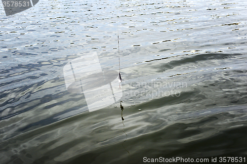 Image of Spinning wobbler hanging on the line above water.