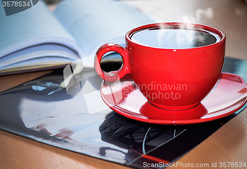 Image of Red cup of coffee on the desk in the office