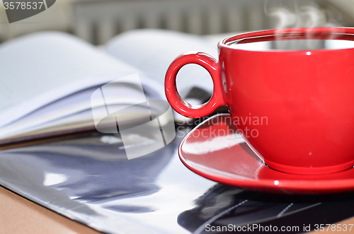 Image of Red cup of coffee on the desk in the office